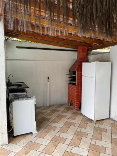 una cocina con 2 neveras blancas y un horno de ladrillo en Sunset Hostel Guarujá en Guarujá