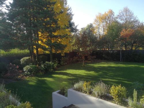 un jardín con césped con árboles y césped en Spacious 3 Bedroom Family Oasis with Sauna, 20 min from Warsaw, en Piaseczno
