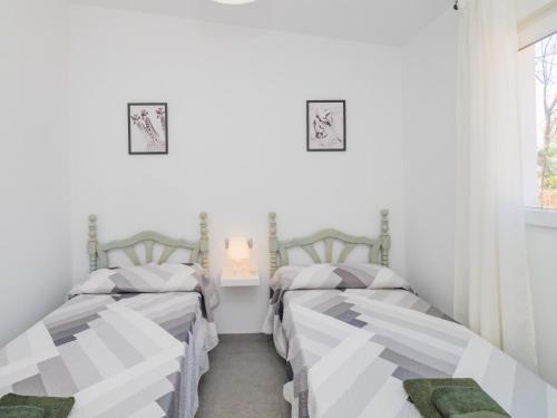 two beds in a room with white walls at Cubo's Finca Armonia in Alhaurín el Grande
