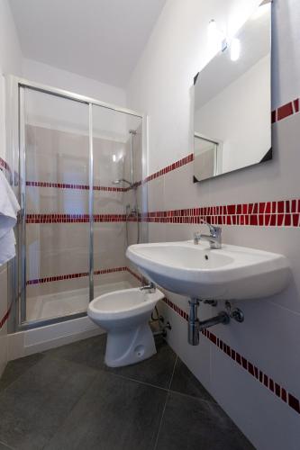 a bathroom with a sink and a toilet and a mirror at Gratteri Holiday Appartamento Vista Mari in Gratteri