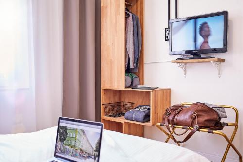 Una televisión o centro de entretenimiento en Hotel am Chlodwigplatz