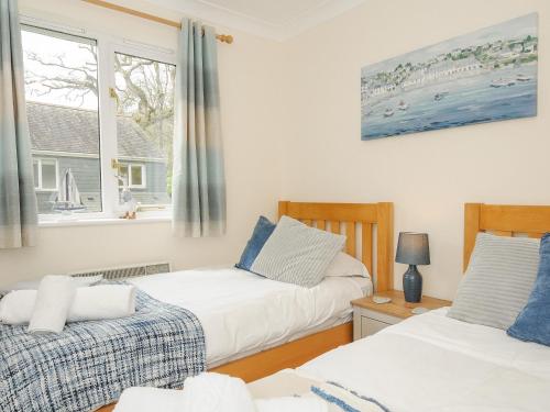 um quarto com 2 camas e uma janela em Woodmans Cottage em Falmouth