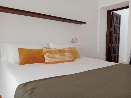 a bedroom with a white bed with orange pillows at Casa Mocan in Arrecife