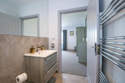 uma casa de banho com um lavatório e um espelho em 4 Bedroom Barn conversion in Beamish County Durham em Durham