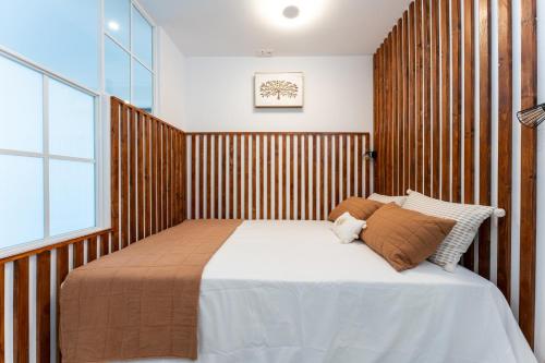 ein Schlafzimmer mit einem großen Bett und einer Holzwand in der Unterkunft MalagaSuite Pool and Sea Views in Fuengirola