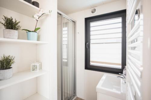 a bathroom with a window and a sink at Hausboot Küstennebel 2 in Ribnitz-Damgarten