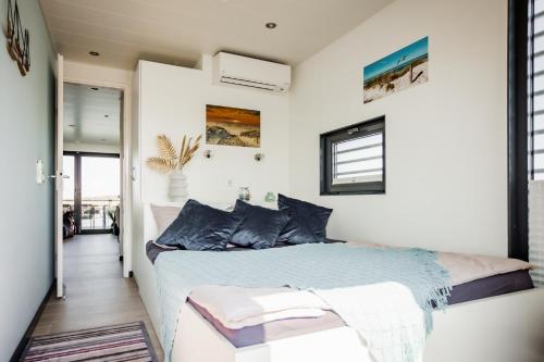 里布尼茨－達姆加騰的住宿－Hausboot Küstennebel 2，一间卧室配有一张带蓝色枕头的床