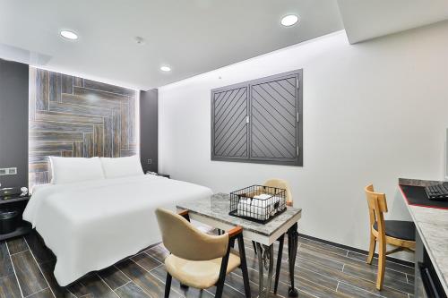 a hotel room with a bed and a desk at Ytt Hotel in Busan