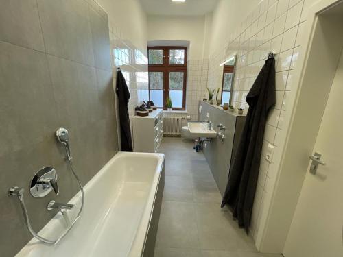 een witte badkamer met een bad en een wastafel bij Charmante Wohnung am Neckar in Bad Wimpfen