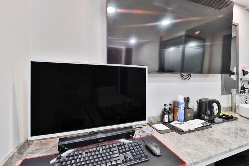 a computer monitor and a keyboard and mouse on a desk at Ytt Hotel in Busan