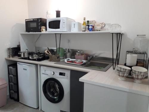 坎佩爾的住宿－"Cosy trendy" - appart étage 1 - Loc'h finistère - N3，厨房配有洗衣机和微波炉。