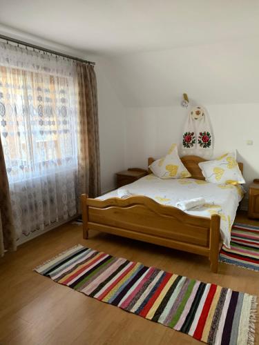 a bedroom with a bed and a rug at Pensiunea Todorica Sergiu in Şieu