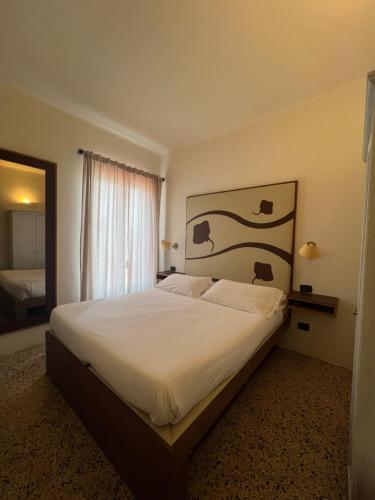 a bedroom with a large bed with white sheets at Locanda Lorena in Portovenere