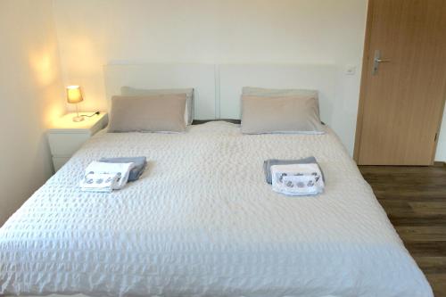 Una cama blanca con dos toallas encima. en Cò d'Franz - PT, en Ponto Valentino