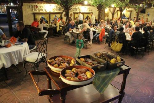 um grupo de pessoas em um restaurante com comida em uma mesa em Luxury Apartments 'Rich' em Velingrad