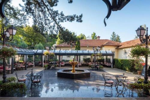 a courtyard with a fountain and tables and chairs at Luxury Apartment 'Rich' in Velingrad