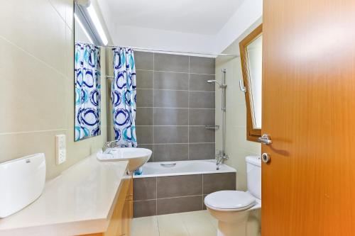 y baño con lavamanos, aseo y lavamanos. en 3 bedroom Villa Athina with private pool and golf views, Aphrodite Hills Resort en Kouklia