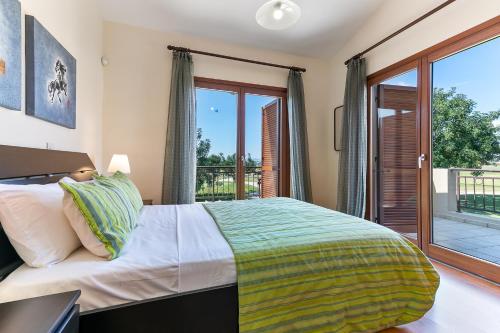 1 dormitorio con 1 cama y balcón en 3 bedroom Villa Athina with private pool and golf views, Aphrodite Hills Resort en Kouklia