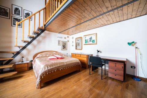 a bedroom with a bed and a desk and a staircase at L'Olea casa vacanze in Campobasso