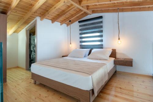 シキアにあるSikia Village Housesの大きなベッドと木製の天井のある寝室