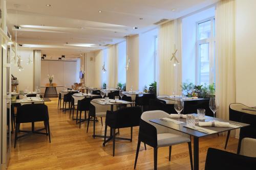 a restaurant with tables and chairs in a room at Boutique Hotel Museum in Belgrade