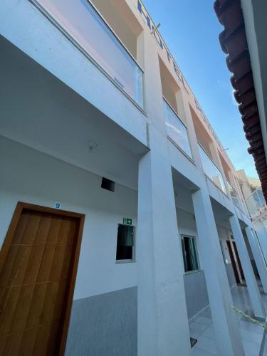 a large white building with a wooden door at Hotel Pousada Dona Ana in Aparecida