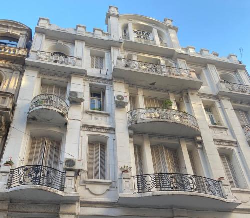 un gran edificio blanco con balcones y ventanas en Gorgeous apartment San Telmo up to 6 people en Buenos Aires