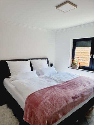 a bedroom with a large white bed with a window at Ferienhaus am Lanzer See in Lanze