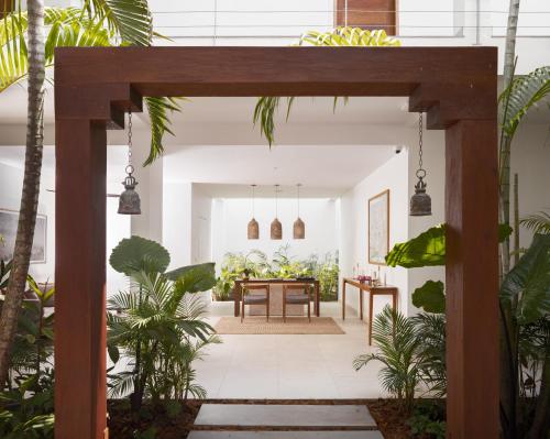 an open courtyard with a dining room with plants at Plantation Urban Resort & Spa in Phnom Penh