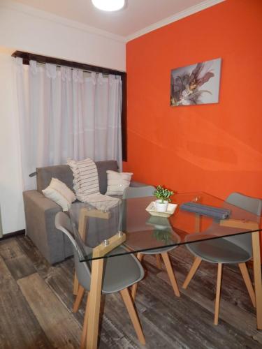 uma sala de estar com um sofá e uma mesa de vidro em Corrientes em Mar del Plata