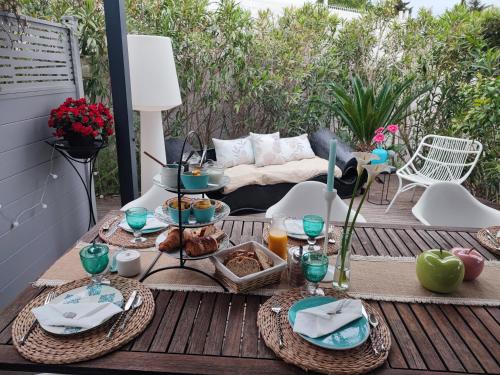 - une table avec des assiettes de nourriture sur une terrasse dans l'établissement Entre Mer et Vignes, à Nissan-lez-Enserune