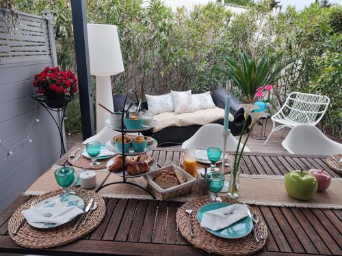 a table with plates of food on a patio at Entre Mer et Vignes in Nissan-lez-Enserune