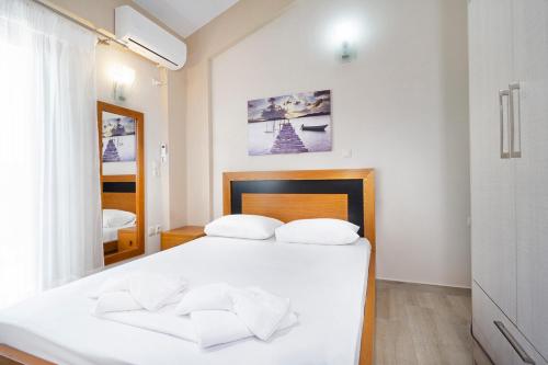 Un dormitorio con una cama blanca con dos almohadas. en Beach Villas, en La Canea