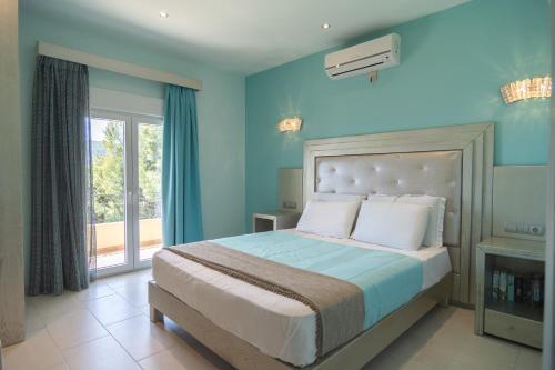a blue bedroom with a bed and a balcony at Villa Theodora View Apartments Eleni in Agios Georgios Pagon