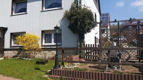 a house with a fence and a street light in the yard at Apartment Bodeweg in Schierke