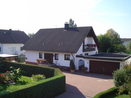 a white house with a black roof and a driveway at Ferienwohnung Benz-Boch in Lahr