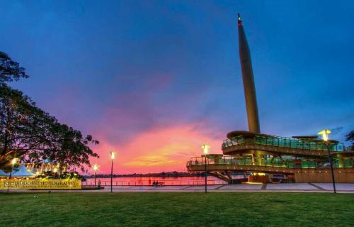 a building with a tower with a sunset in the background at KLIA Ehsan Residence Pool View 8 PAX Air-Con Suite in Sepang