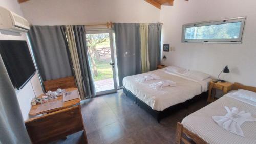 a hotel room with two beds and a window at Dormis:Lodesilvi in Merlo