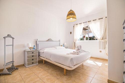 Una habitación blanca con una cama y una ventana en El Olivar Beach Golf, en Caleta de Fuste