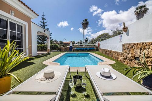 un patio trasero con piscina y una villa en El Olivar Beach Golf, en Caleta de Fuste