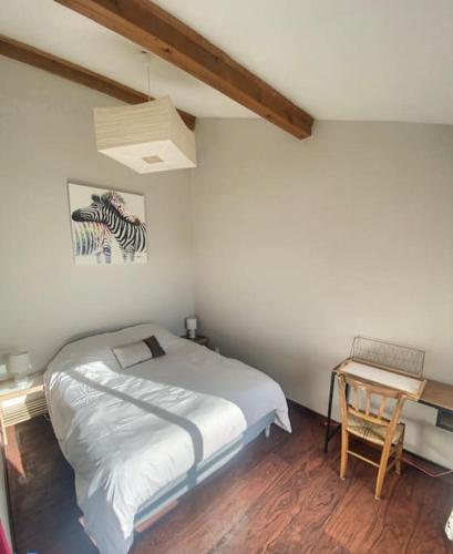 um quarto com uma cama e uma mesa com uma secretária em Le Matabiau - Confortable T1bis proche gare em Toulouse