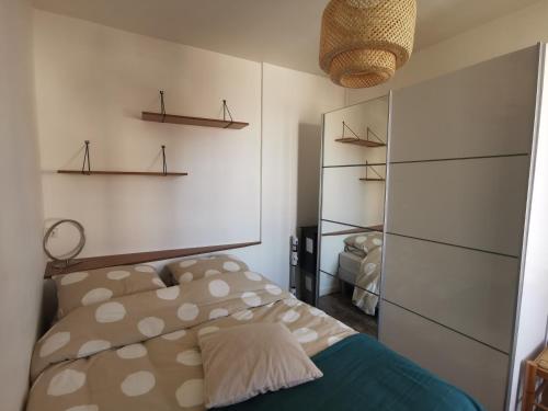 - une chambre avec un lit et des étagères dans l'établissement Les chants du crépuscule, à Granville