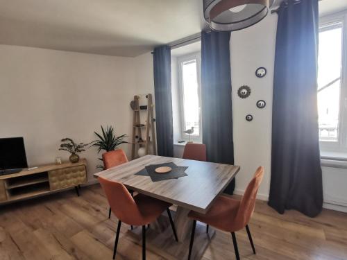 une salle à manger avec une table et des chaises en bois dans l'établissement Les chants du crépuscule, à Granville