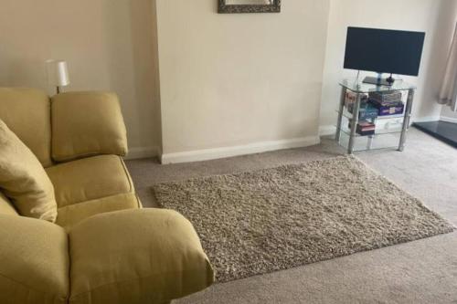 a living room with a couch and a television at Julia’s flat in Maryport