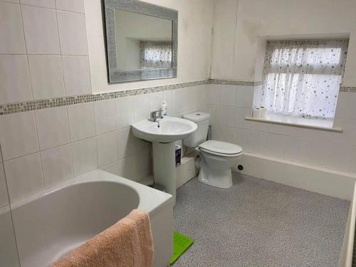 a bathroom with a sink and a tub and a toilet at Julia’s flat in Maryport
