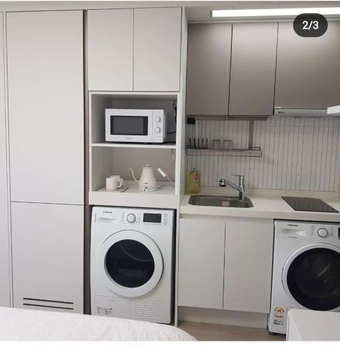 a kitchen with a microwave and a washing machine at Sokcho Summitbay 1701 "Ocean View" in Sokcho