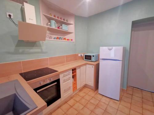 eine Küche mit einem weißen Kühlschrank und einer Theke in der Unterkunft Le Costa Rica - Grand appartement centre ville in Boulogne-sur-Mer