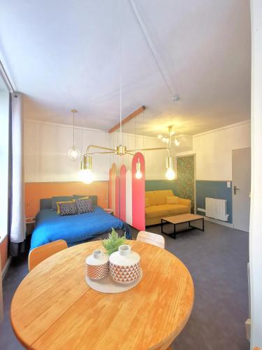 - un salon avec une table, un lit et un canapé dans l'établissement Le Costa Rica - Grand appartement centre ville, à Boulogne-sur-Mer