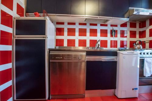 a small kitchen with red and white walls at 080 - La Villa storica Il Vigneto 45b, Terrazza sul Mare - Parcheggio privato GRATIS in Moneglia