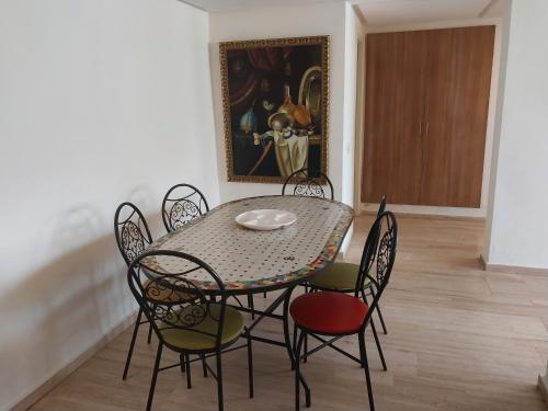 Appartement Hay Riad في الرباط: غرفة طعام مع طاولة وكراسي